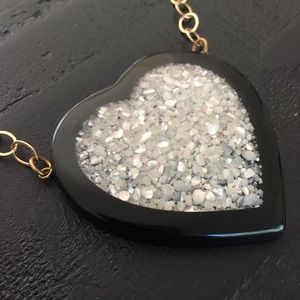 Black heart necklace on gold medal link chain.